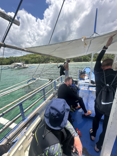 Scuba divers with the 2025 Trident Warriors trip to the Philippines on the boat and headed to the next dive location