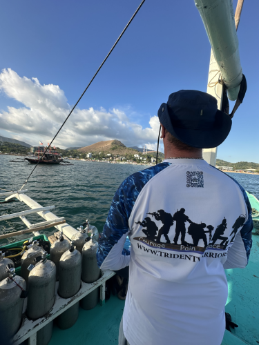 A Trident Warriors scuba diver enjoying the view from the boat while in the Philippines for the 2025 scuba trip